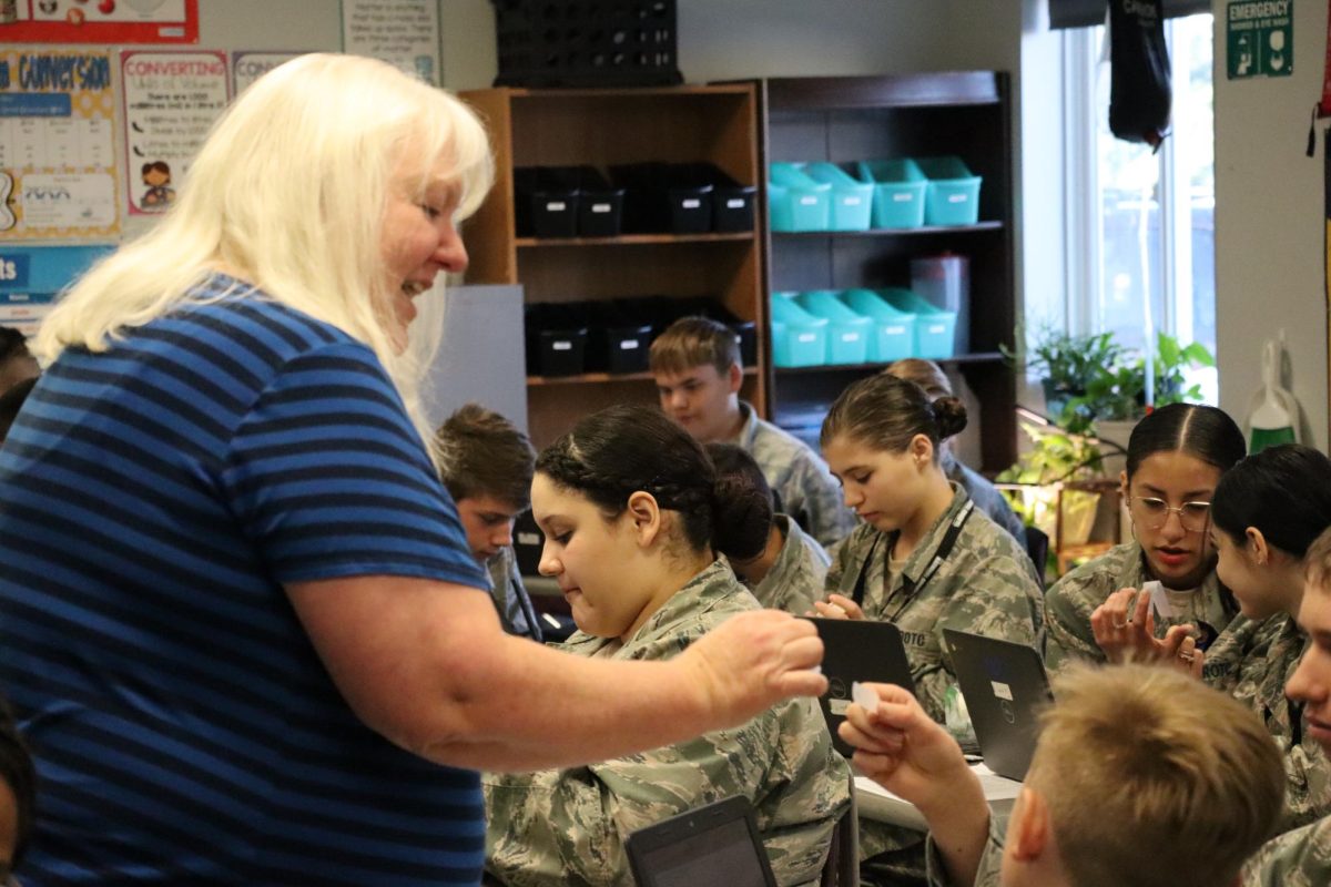 Captain Alison Carlisi helps a cadet during 8th Grade Science. 