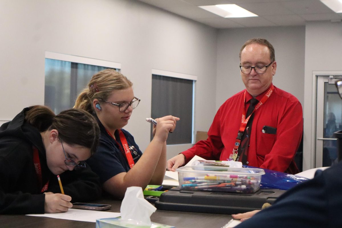 Cadet Kallie Rounds and Charlotte Walston work on their Hope Squad project with Mr. Wendel.