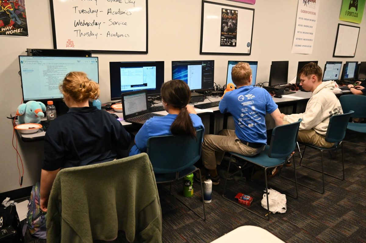 Cadets Charlotte Schneider, Charly Love, Jacob Schneider, and Kayson Anderson work on their Cyberpatriot project during a Friday late afternoon competition.