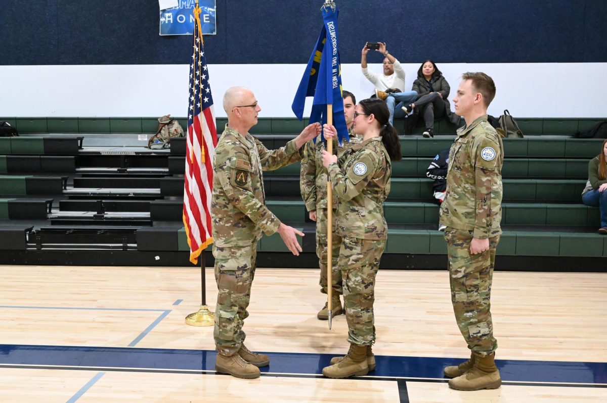 The changing of Wing Commander at the end of the first semester this year. Lt. Col. Tisher takes the wing guide on from Cadet Col. Wright to Cadet Col. Coady Maples. 